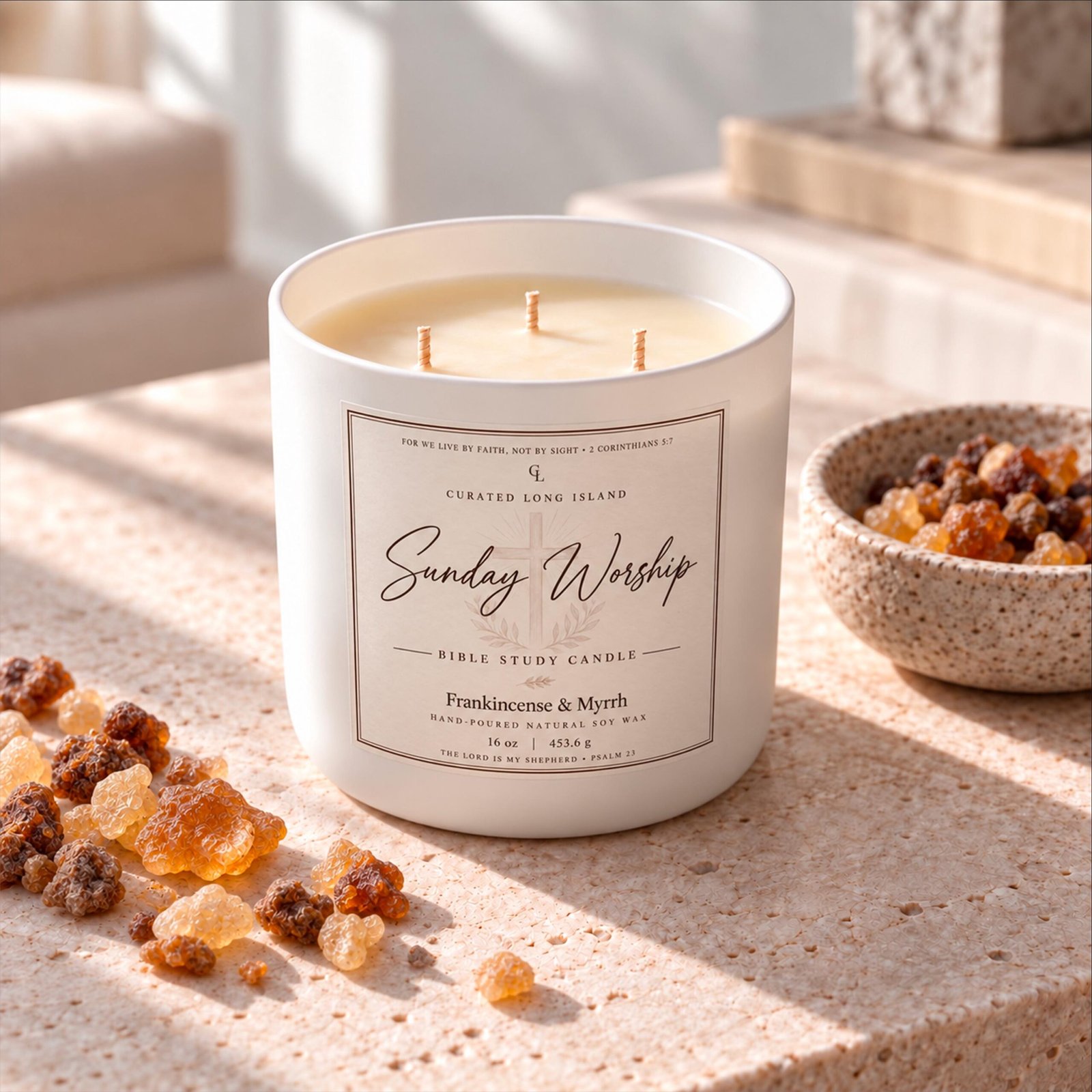 Sunday Worship candle in a matte ivory vessel on a sunlit stone surface with amber frankincense resin