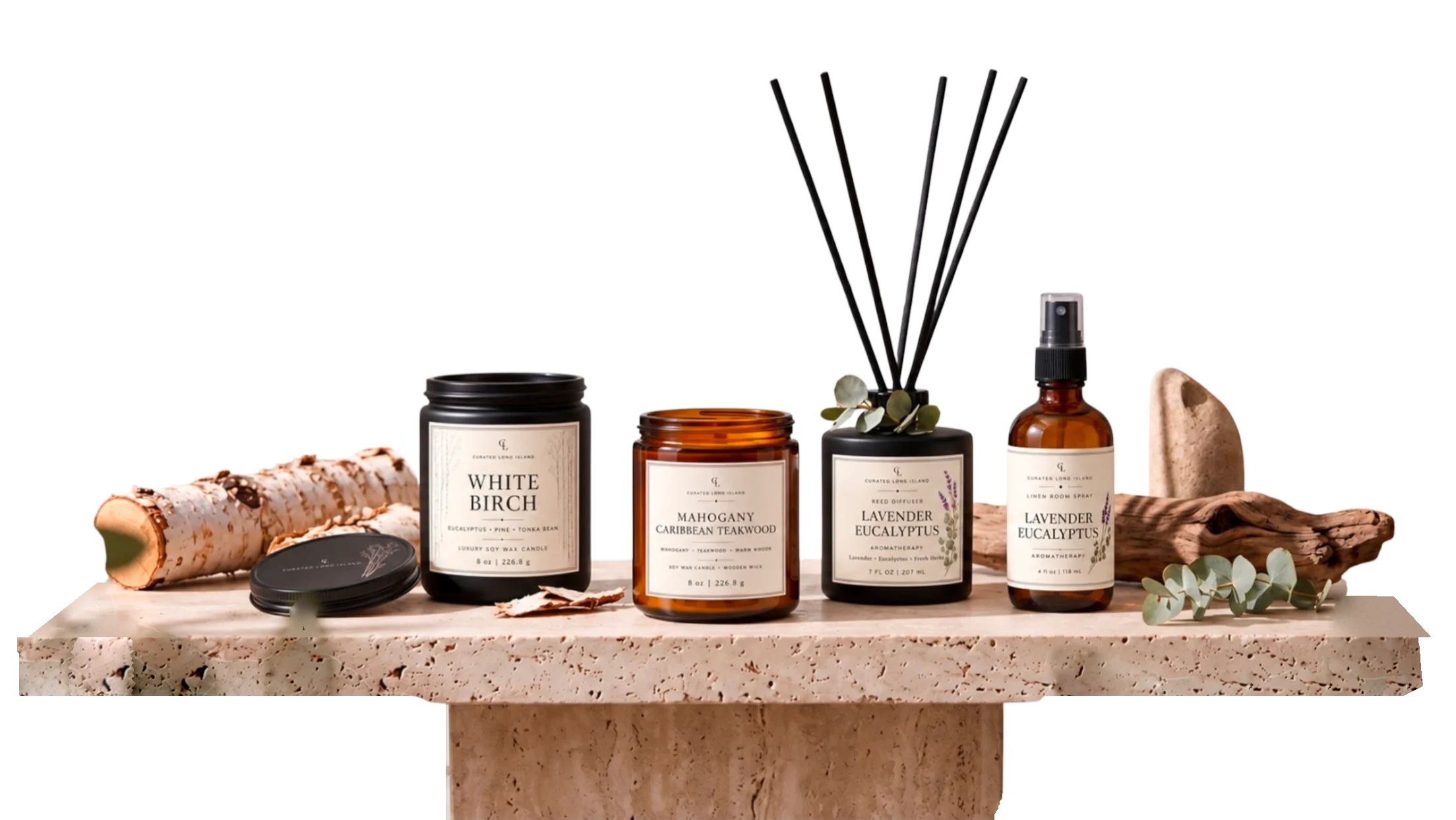 White Birch and Mahogany Caribbean Teakwood candles, a Lavender Eucalyptus reed diffuser and room spray on a travertine plinth